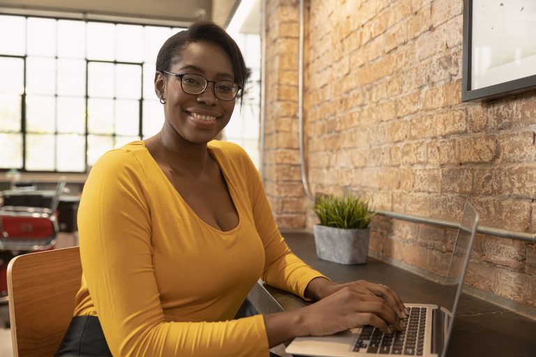 femme-souriant-derrière-son-écran